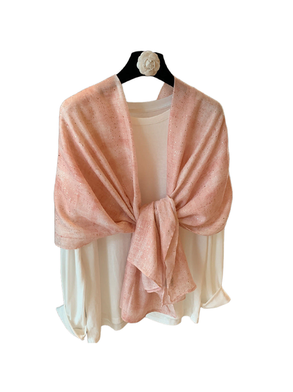 Pink rectangular scarf with metallic-look flecks tied over a white top