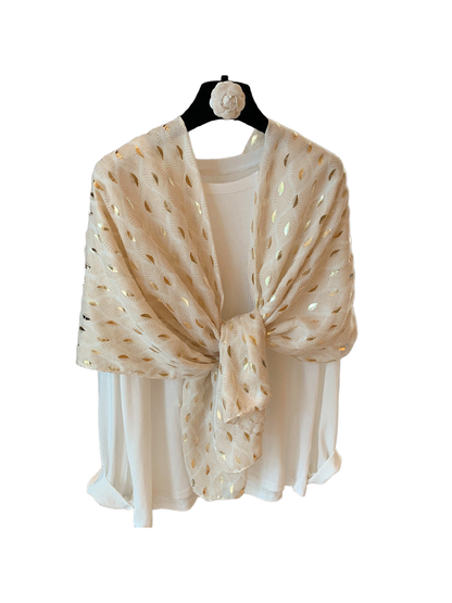 Beige scarf with pale frond pattern and metallic-look accents, tied over a white top