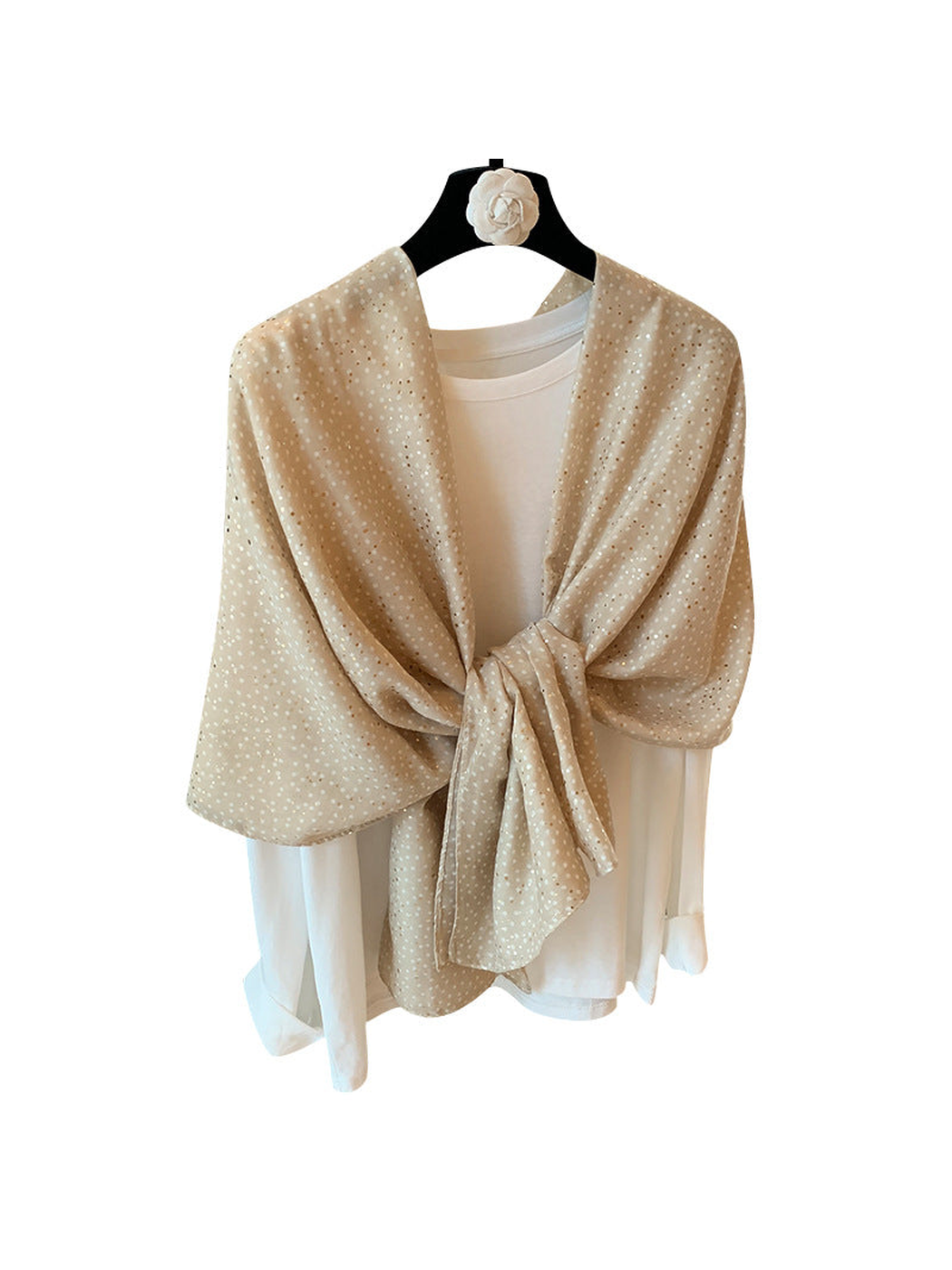 Beige dotted scarf draped and knotted over a white top