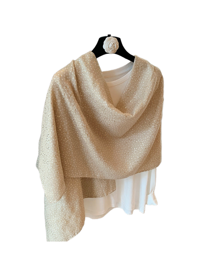 Beige dotted scarf arranged in a loose draped wrap