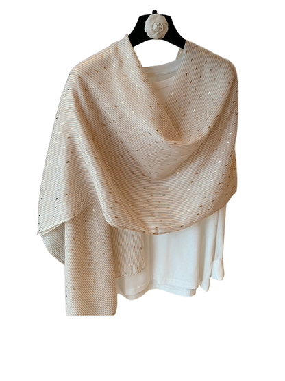 Beige pleated scarf loosely draped over a white top