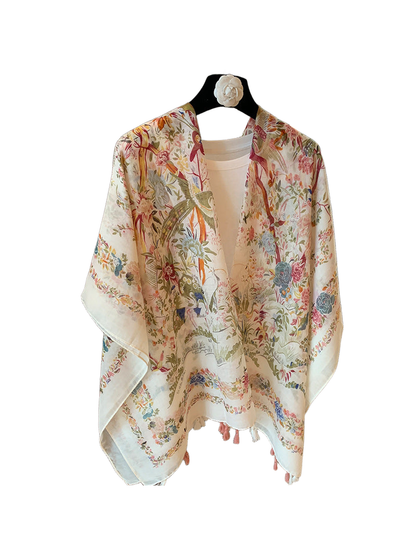 Ivory scarf with multicolor floral and bird print draped over a white top
