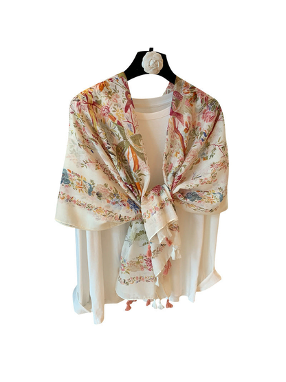 Floral and bird print scarf with tasseled edges in a tied drape