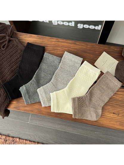 Black, gray, cream and khaki open-toe socks displayed together