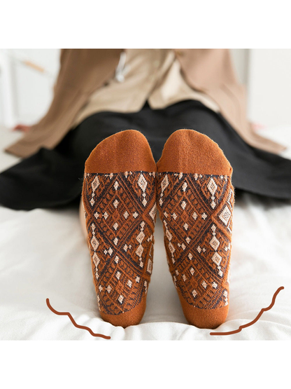 Close-up of orange diamond-pattern socks showing the soles and contrasting toes