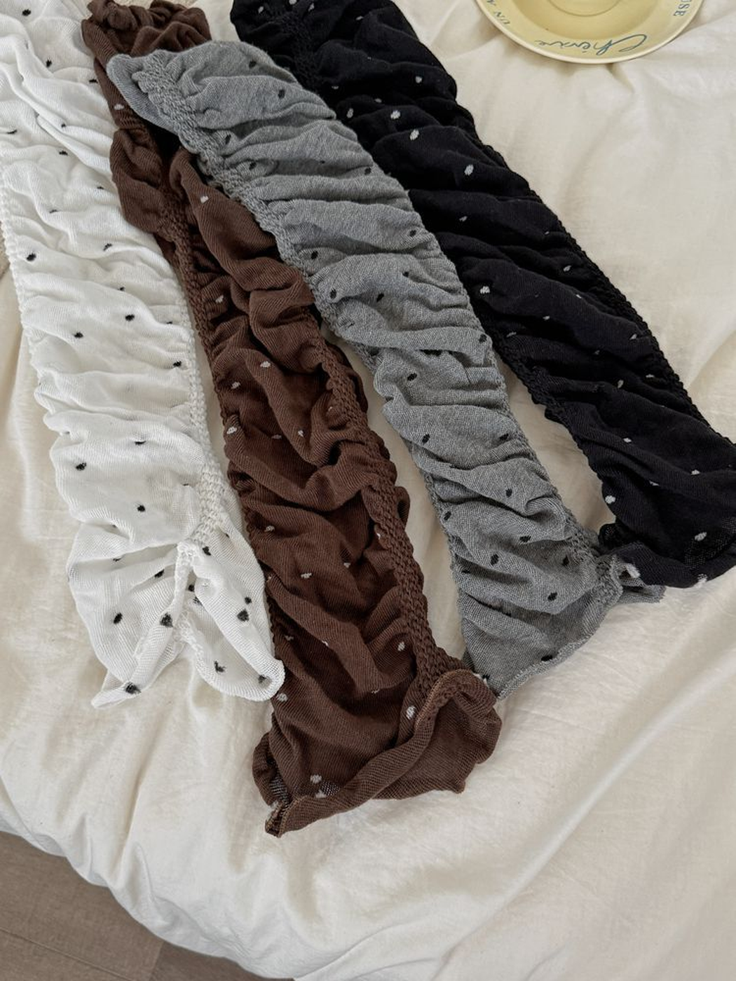 White, brown, gray and black polka-dot ruched leg warmers laid out together