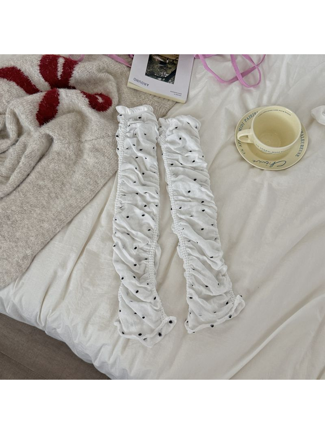 White polka-dot ruched leg warmers laid flat as a pair