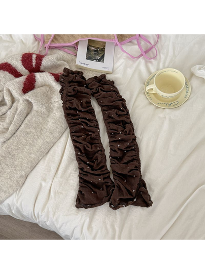 Brown polka-dot ruched leg warmers laid flat as a pair