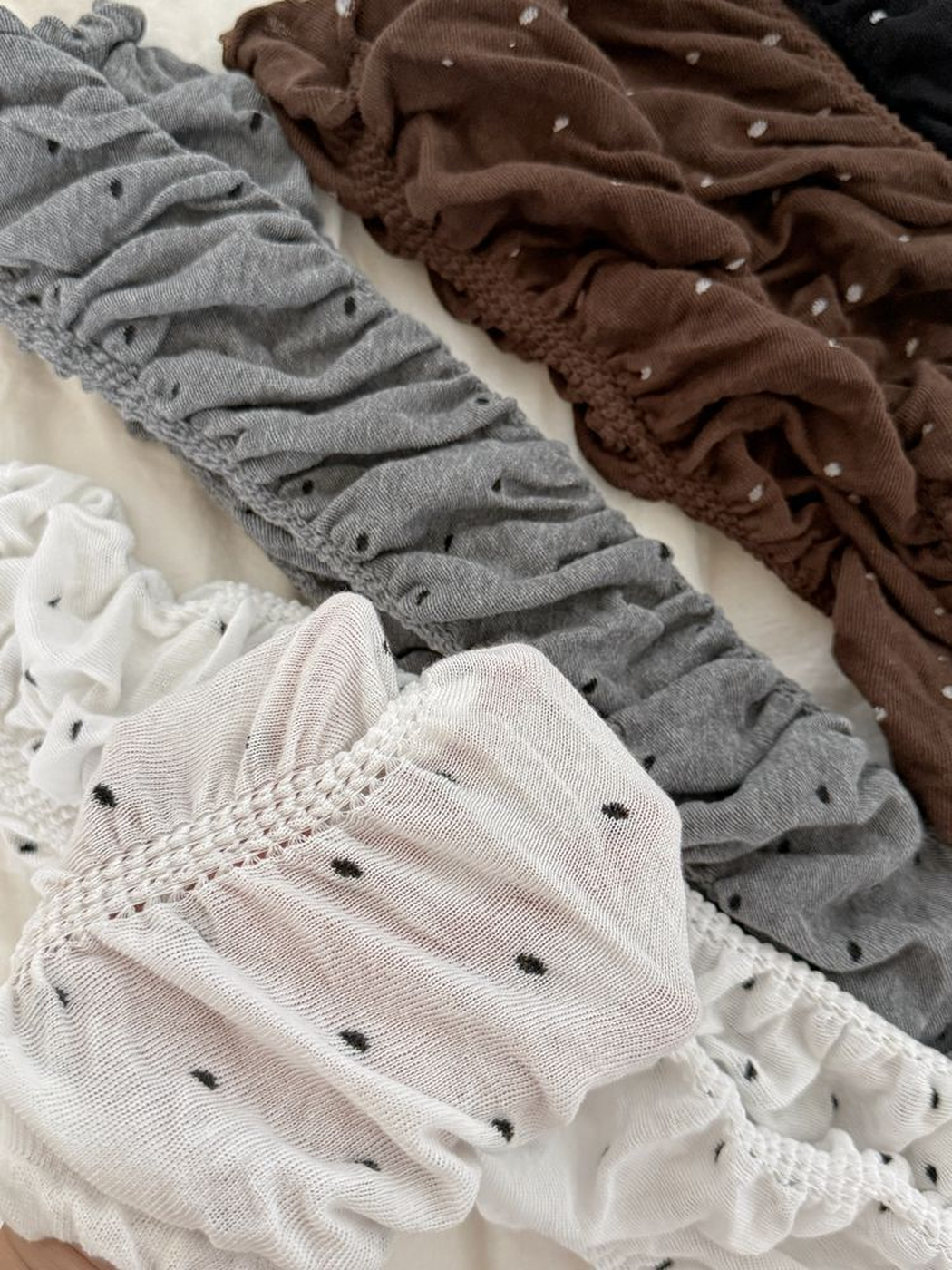 Close-up of the ruched texture and contrasting polka dots in white, gray and brown