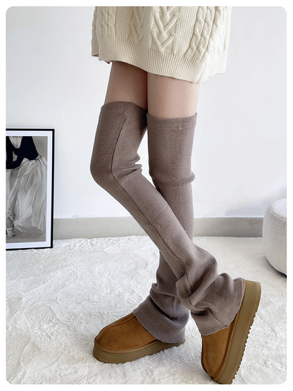 Brown ribbed over-the-knee leg warmers worn with brown shoes in a crossed-leg pose
