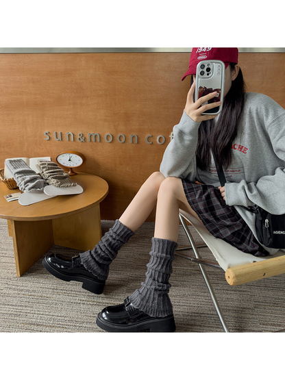 Dark Gray ribbed ruffle-edge socks worn with black loafers while seated
