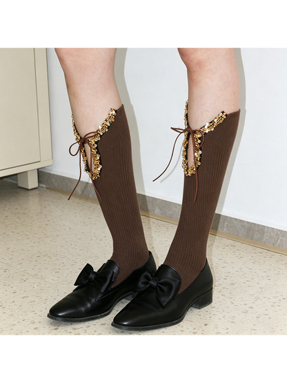 Brown ribbed knee-high socks with front cutouts and tie bows, standing view