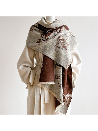 Brown floral scarf wrapped across the shoulders of a mannequin wearing an ivory coat.