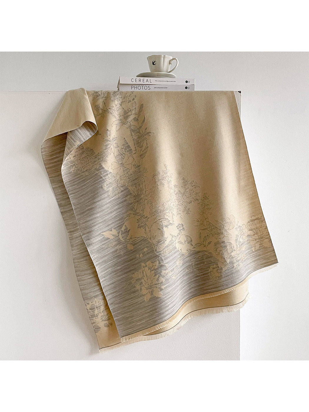Ivory floral scarf draped open with gray striped borders and short fringe.