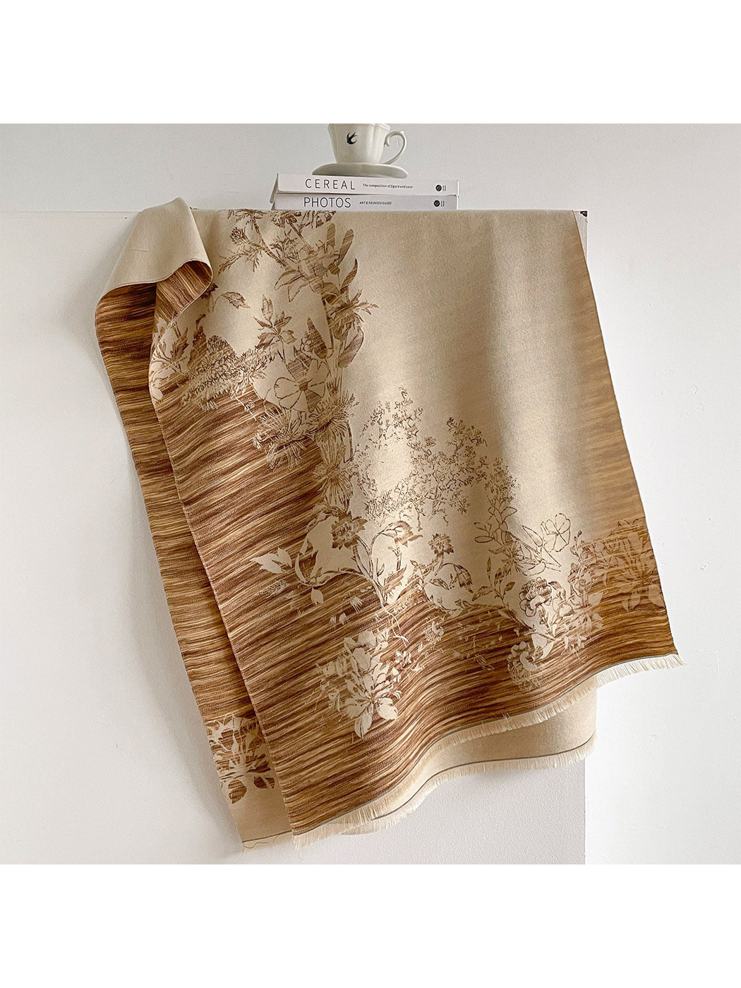 Camel floral scarf draped open with contrasting striped borders and short fringe.