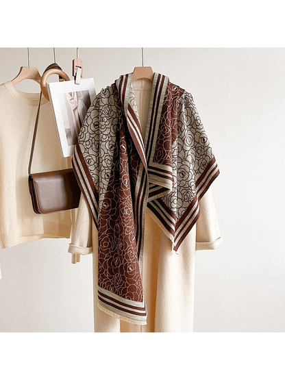 Brown / Ivory floral scarf draped over a cream coat on a hanger.