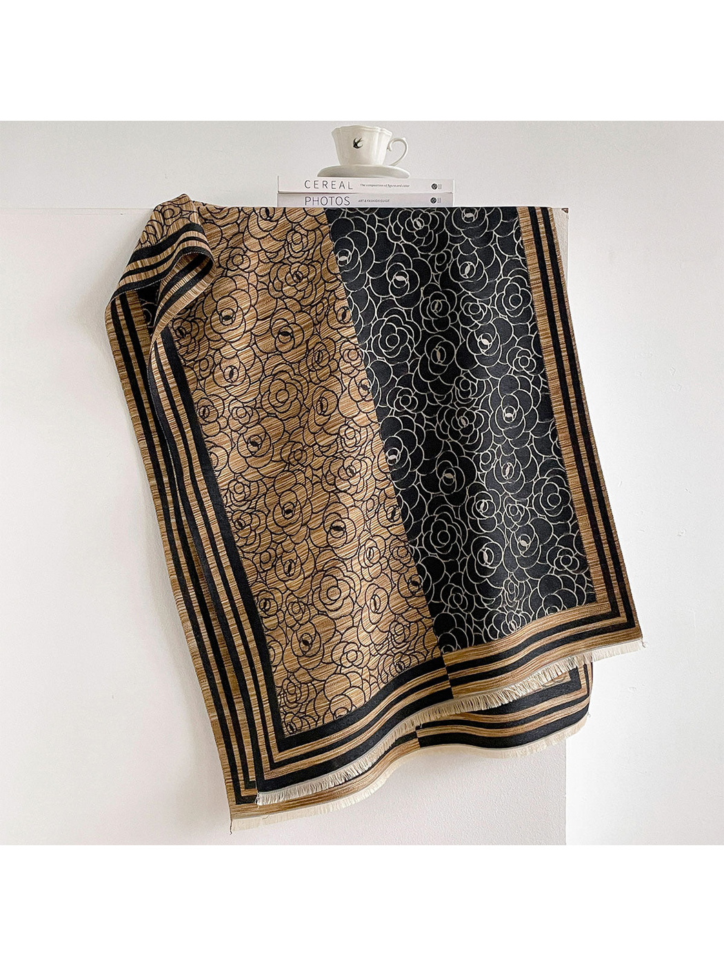 Black / Gold floral scarf draped to show contrasting panels, striped borders and short fringe.