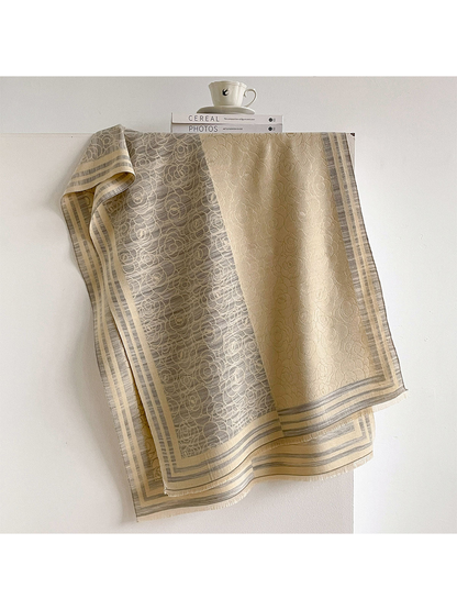 Gray / Cream floral scarf draped to show contrasting panels, striped borders and short fringe.