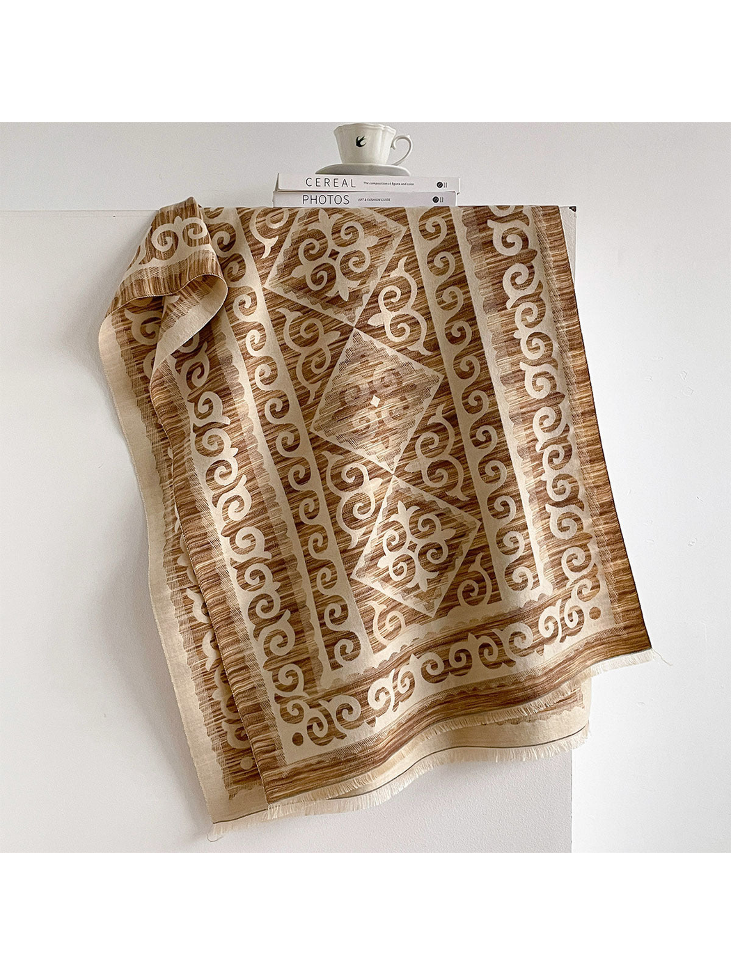 Camel / Cream scarf draped open with scroll borders, diamond medallions, and short fringe.