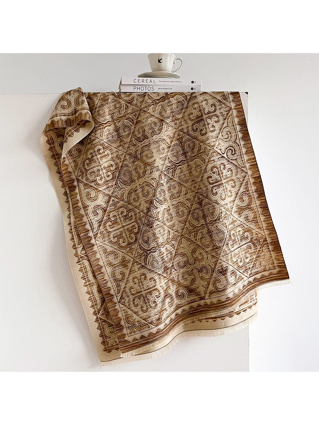 Brown ornamental scarf with geometric border and fringed ends