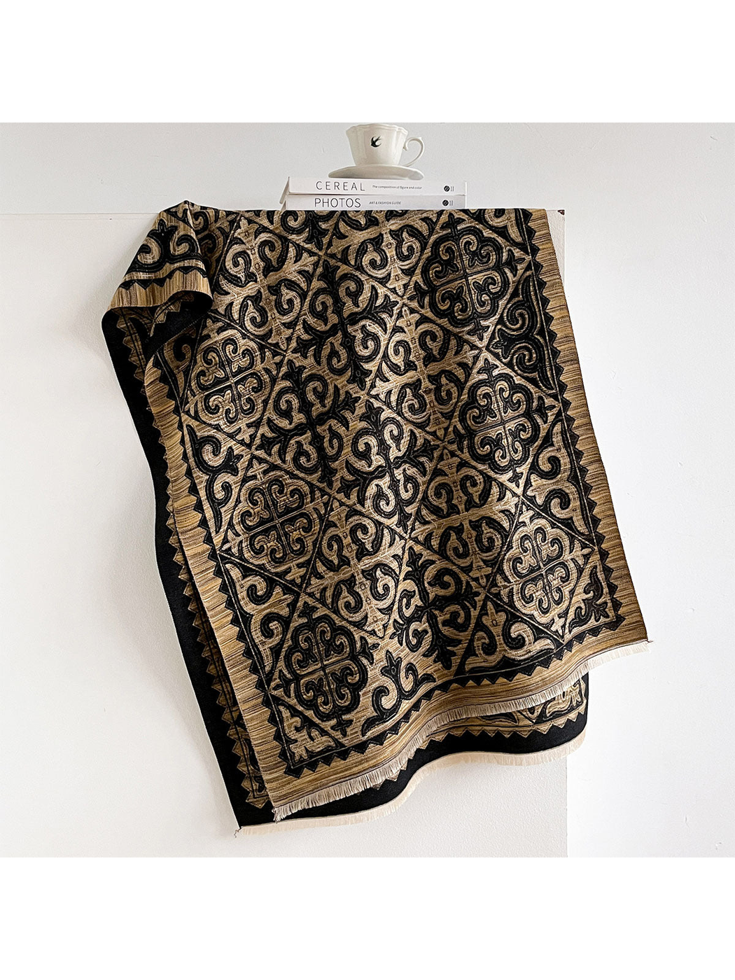 Gold ornamental scarf with dark geometric border and fringed ends