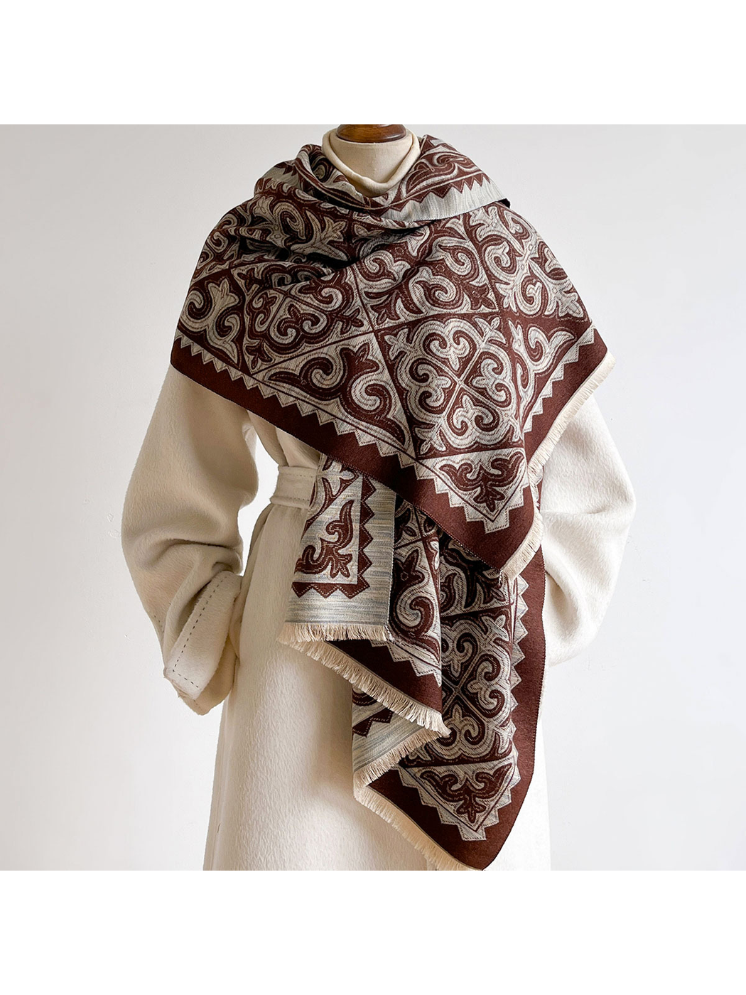 Brown ornamental scarf wrapped across the shoulders of a mannequin
