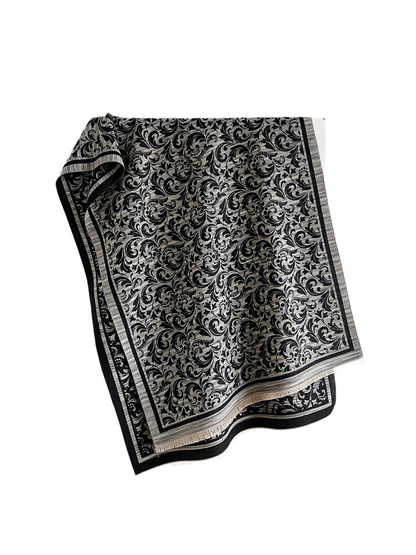 Black Gray scarf draped open on white, with scrolling leaves, a striped border and short fringe.
