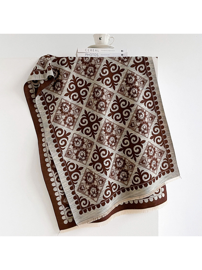 Coffee scarf draped open with contrasting floral diamonds, ornamental scrolls, a patterned border and short fringe.