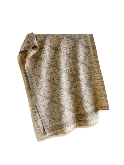 Greige scarf on a white background with cream floral and scroll motifs, a decorative border and short fringe.