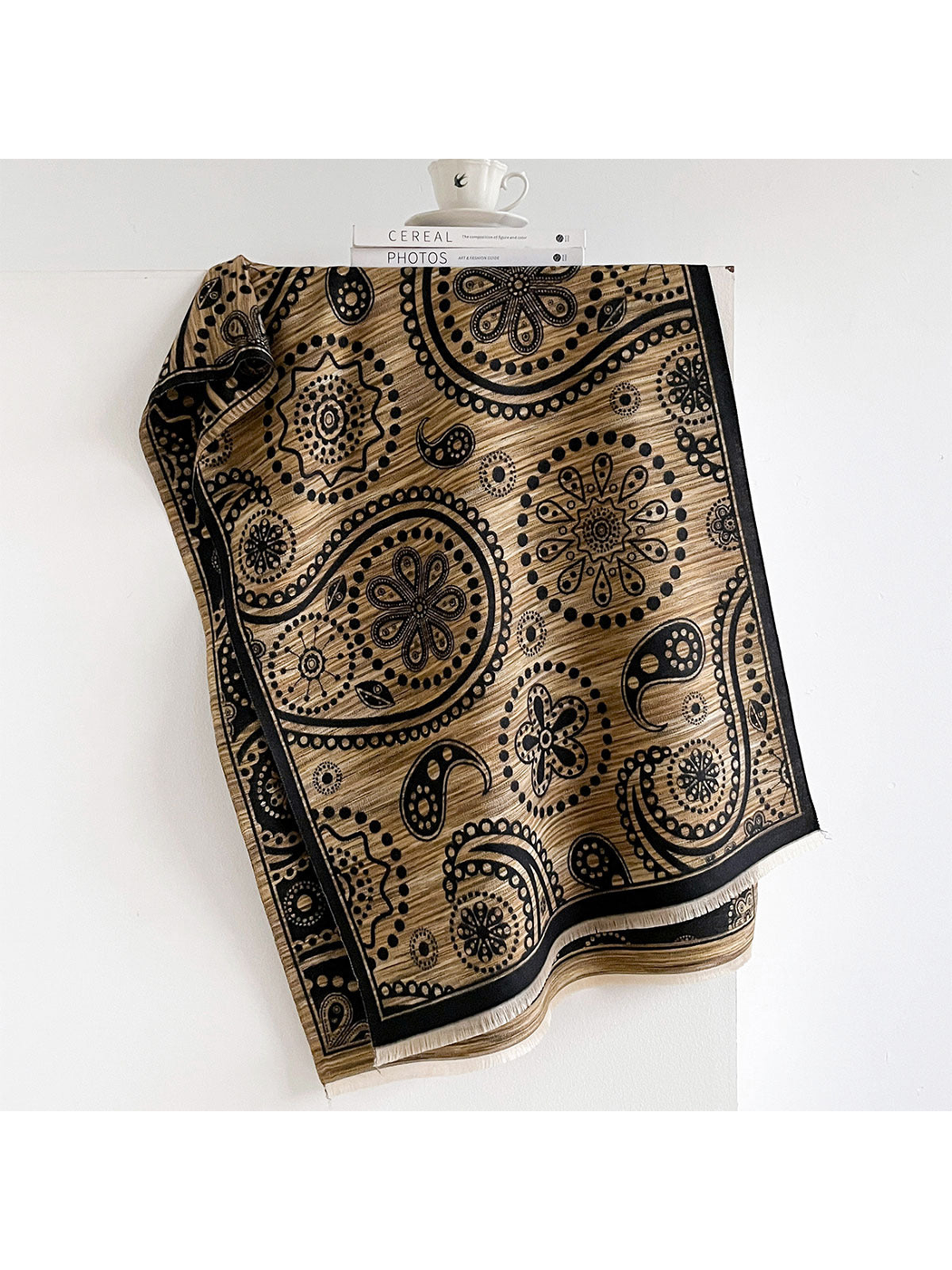 Black / Gold paisley scarf draped to show its patterned border and short fringe.