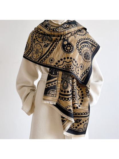 Black / Gold paisley scarf wrapped across the shoulders of a mannequin wearing a cream coat.