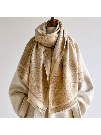 Multicolor scarf looped around a mannequin over a cream coat, with paisley panels and fringed ends hanging down the front.
