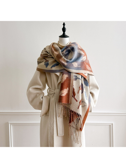 Cream feather-pattern scarf wrapped across a mannequin's shoulders, with blue and rust sections facing outward.