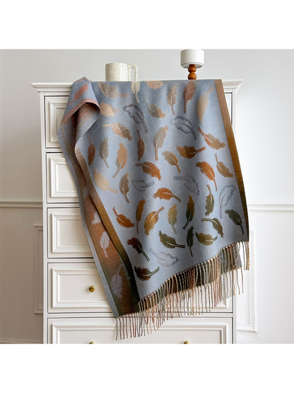 Light Blue feather-pattern scarf with contrasting borders and twisted fringe, draped over a white dresser.