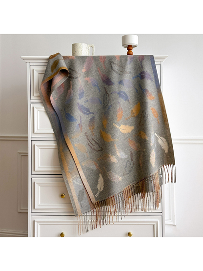 Gray scarf spread over a white dresser, showing the feather pattern, border bands and fringed ends.