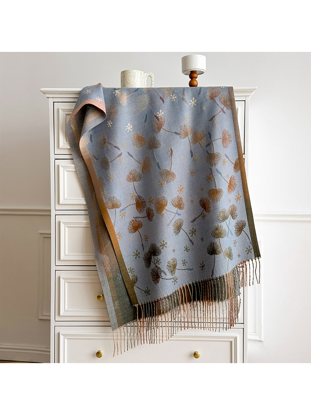 Blue Gray floral scarf draped over a white chest, showing contrasting borders and fringed ends.