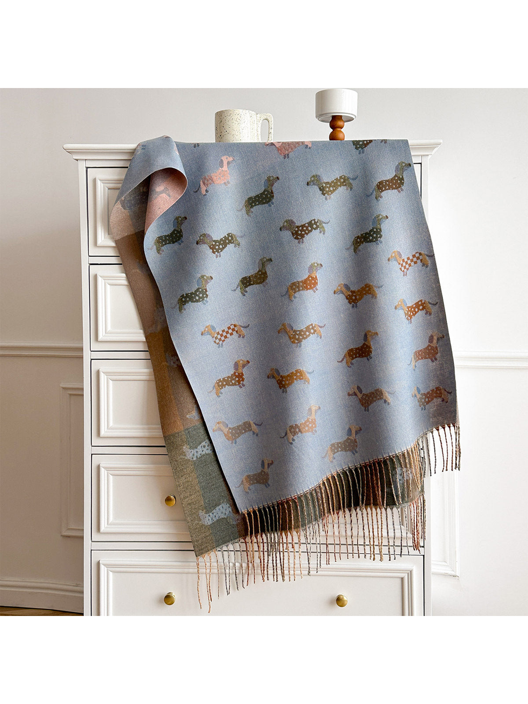 Blue Gray dachshund-pattern scarf draped over a cabinet, with contrasting reverse and fringed ends.