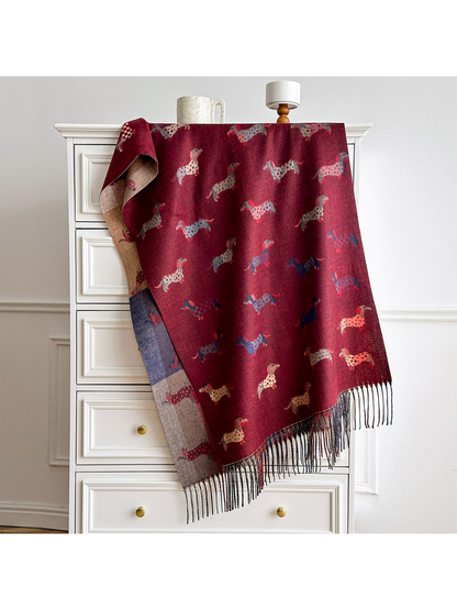 Burgundy scarf spread over a cabinet, revealing rows of dachshund motifs, a color-block reverse and fringe.