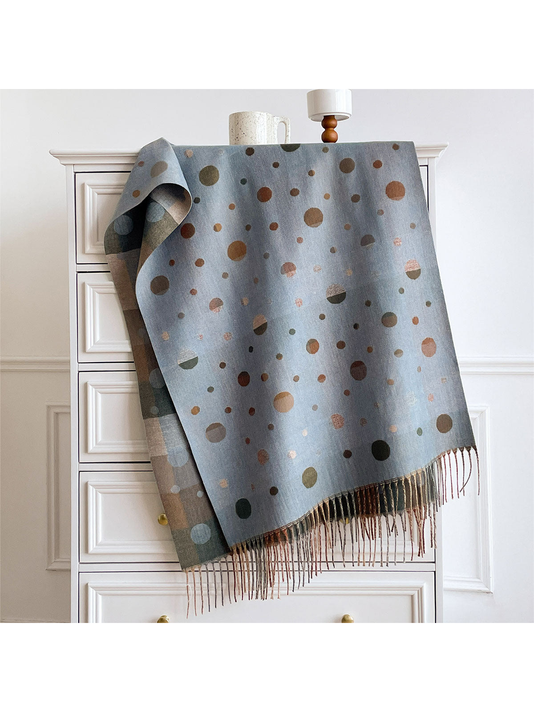 Blue Gray polka dot scarf draped over a cabinet, showing the color block reverse and fringed ends.