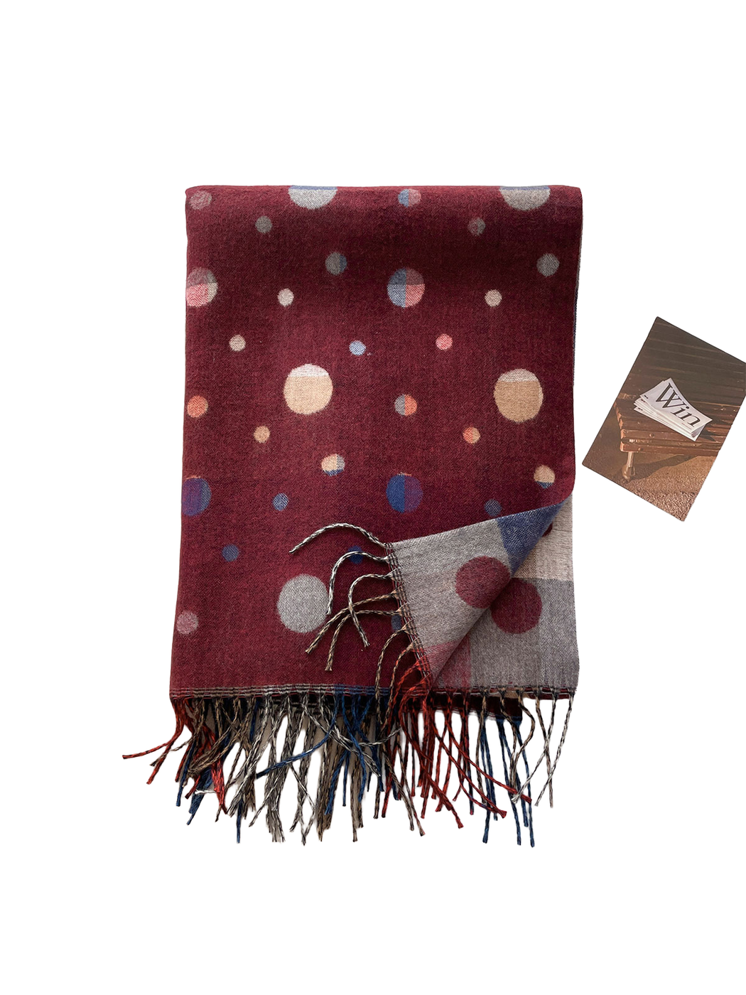 Folded Burgundy scarf showing polka dots, the contrasting reverse, surface texture and twisted fringe.