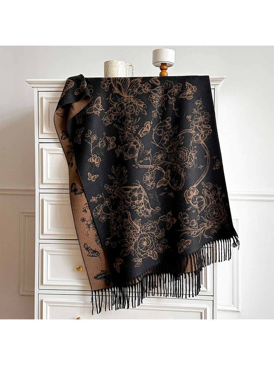 Black / Coffee floral and butterfly scarf draped over a cabinet, with contrasting reverse and fringed ends visible.