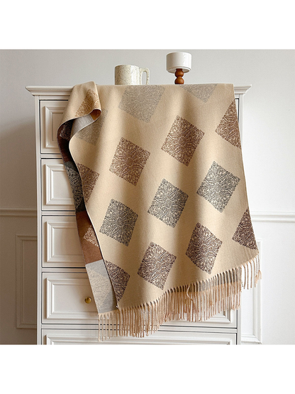 Beige scarf draped over a cabinet with repeating paisley diamonds, a contrasting reverse and long fringe.