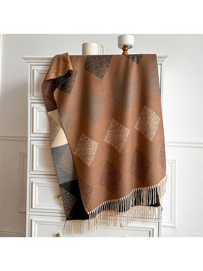 Camel scarf with paisley diamond motifs and pale fringe draped over a cabinet, revealing its contrasting reverse.