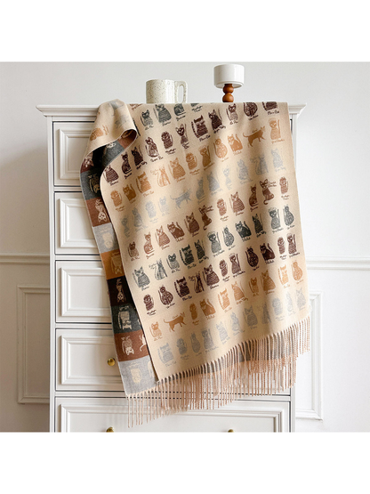 Beige cat-pattern scarf draped over a dresser, showing its contrasting reverse and fringed ends.