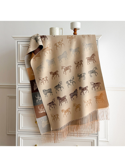 Beige horse motif scarf draped over a dresser, with a contrasting color block reverse and long fringe.