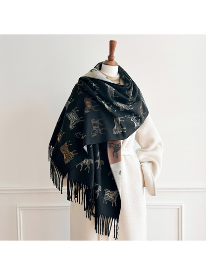 Black horse motif scarf draped broadly around a mannequin's shoulders over a cream coat, with fringed ends hanging down.