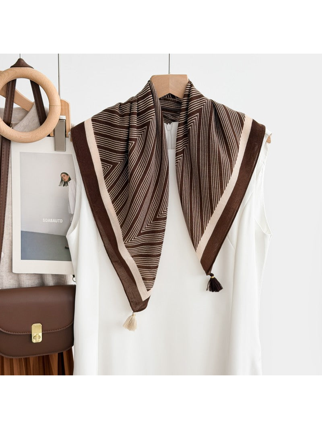 Dark Brown chevron-pattern scarf with contrasting borders and corner tassels draped over a white sleeveless top.