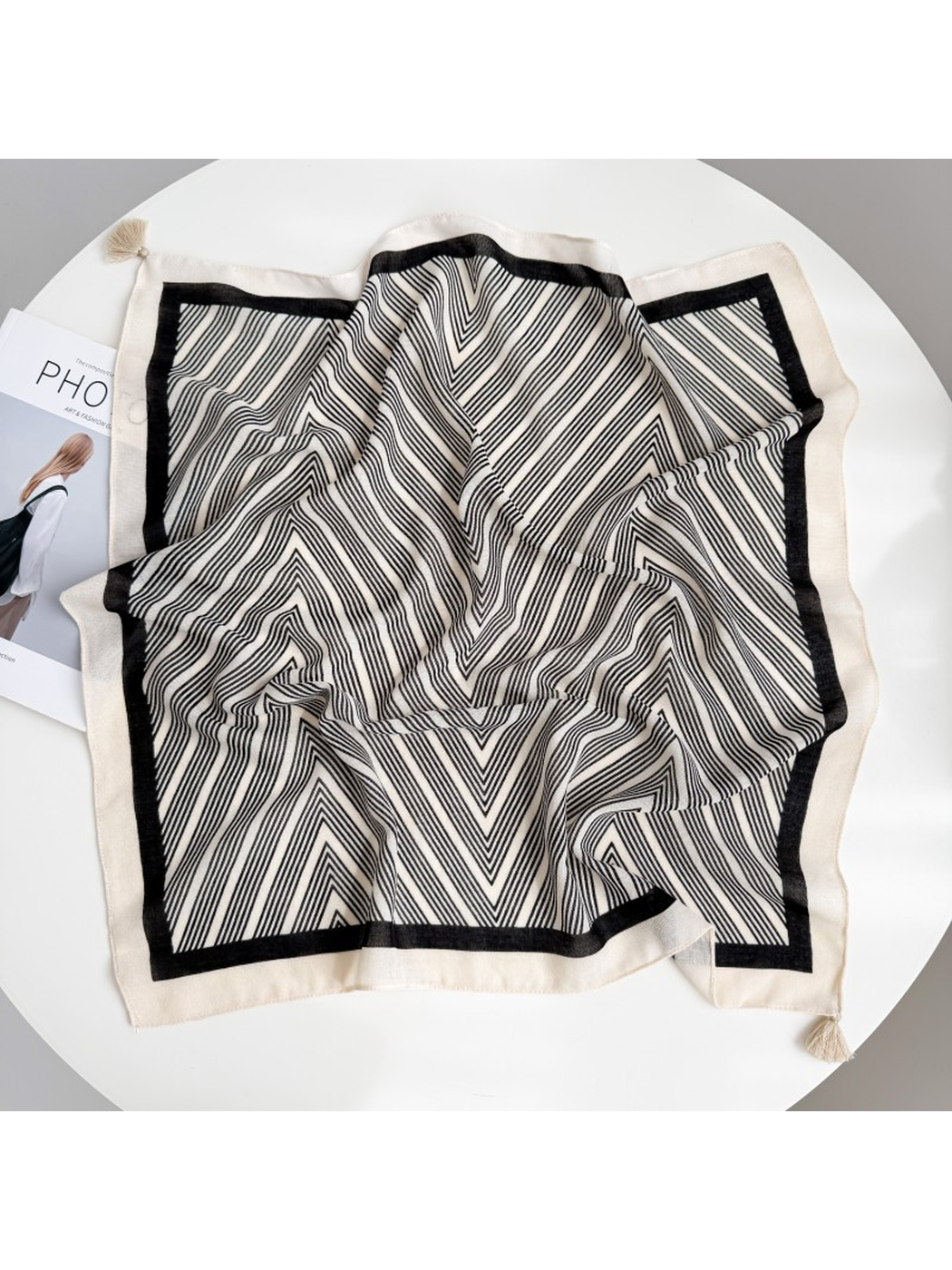Ivory square scarf spread out with fine black chevrons, a black inner border and ivory corner tassels.