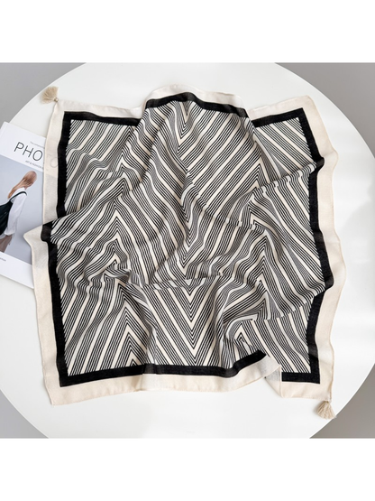 Ivory square scarf spread out with fine black chevrons, a black inner border and ivory corner tassels.