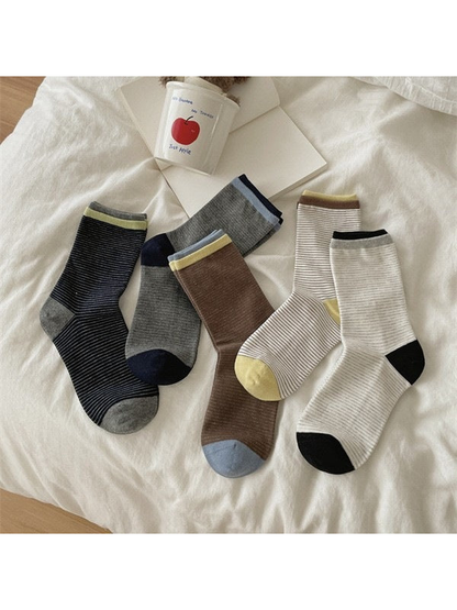 Striped crew socks in White, Ivory, Heather Gray, Brown and Black arranged with contrasting heels and toes visible.